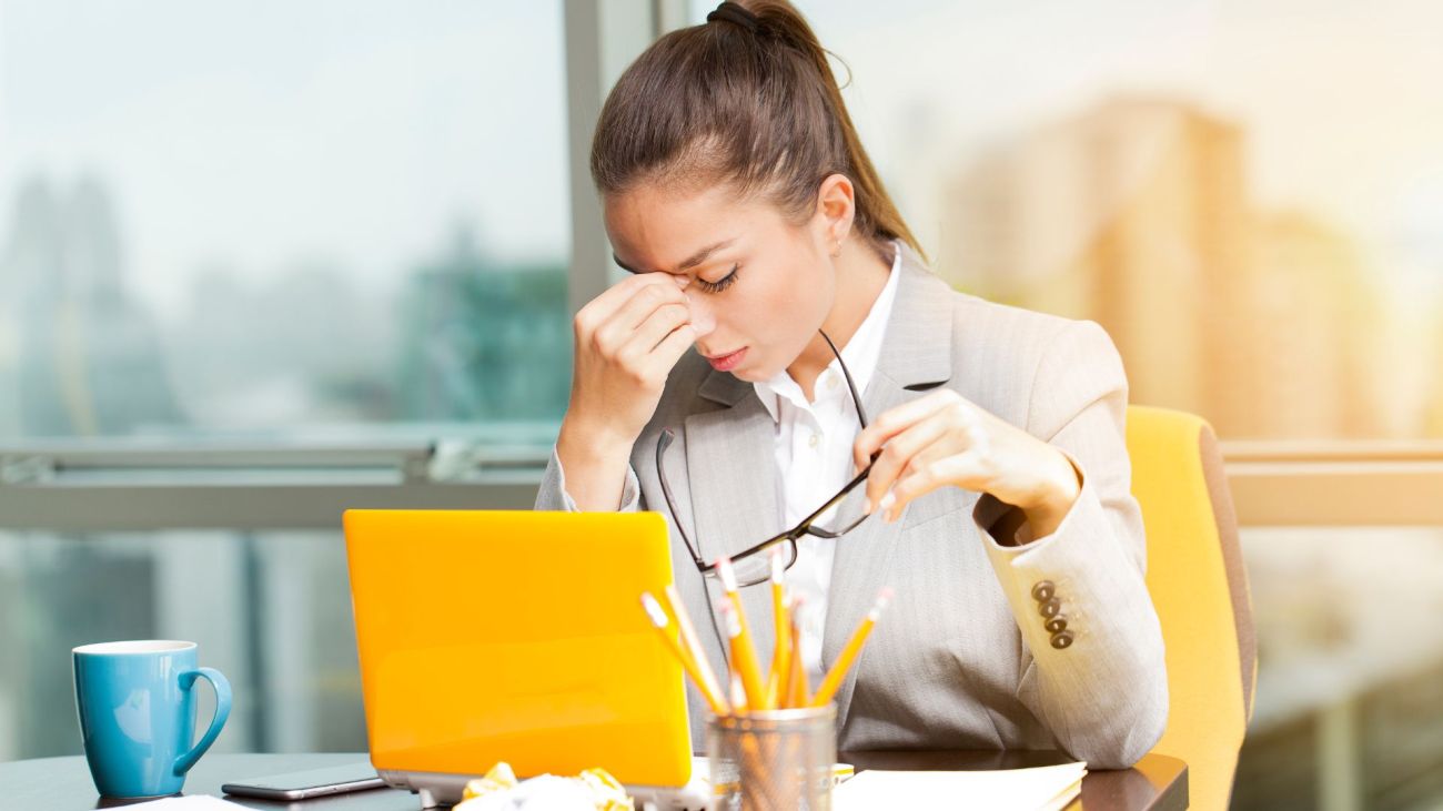 Mujer delante de pc preocupada haciendo números por que no llegar a final de mes